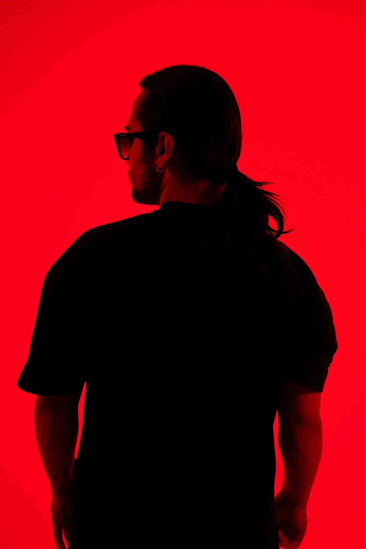 Black silhouette portrait against a red wall — Soner Erdoğan studio shoot